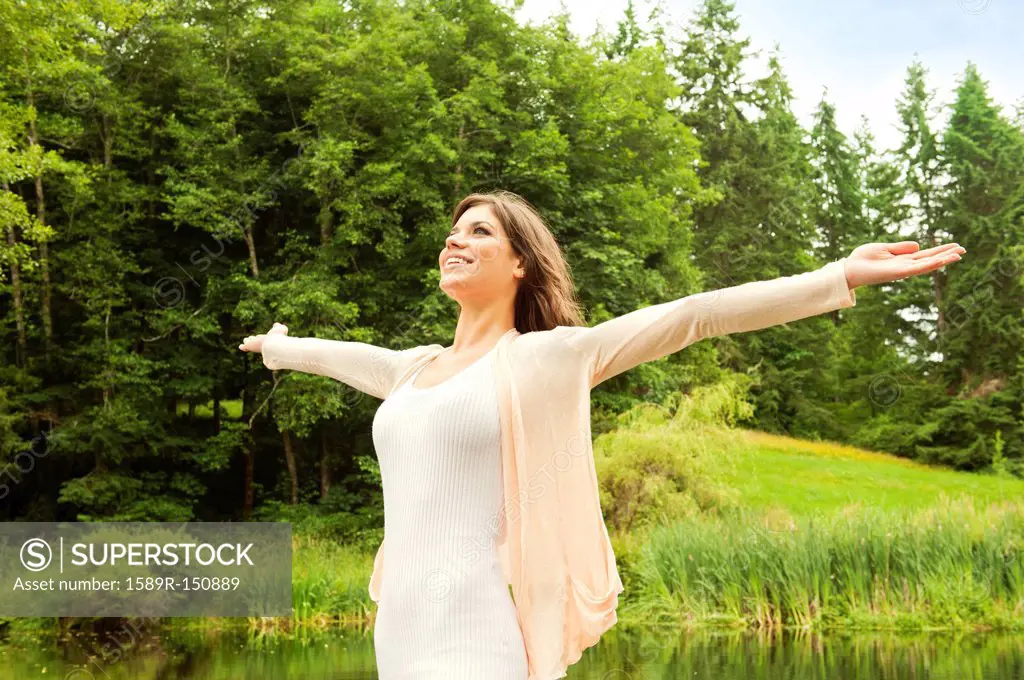 Caucasian woman standing outdoors with arms outstretched