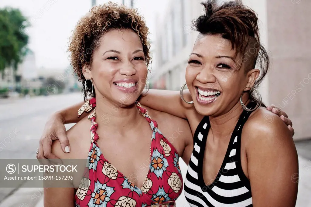 Smiling women hugging on urban street