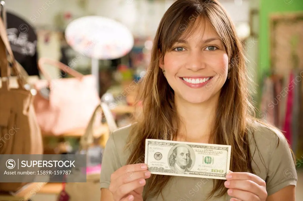 Hispanic woman holding cash in store