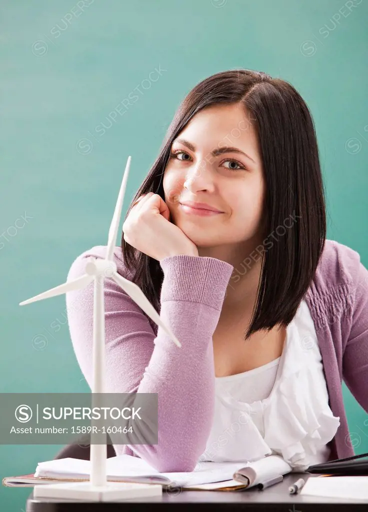 Caucasian woman sitting with wind turbine model