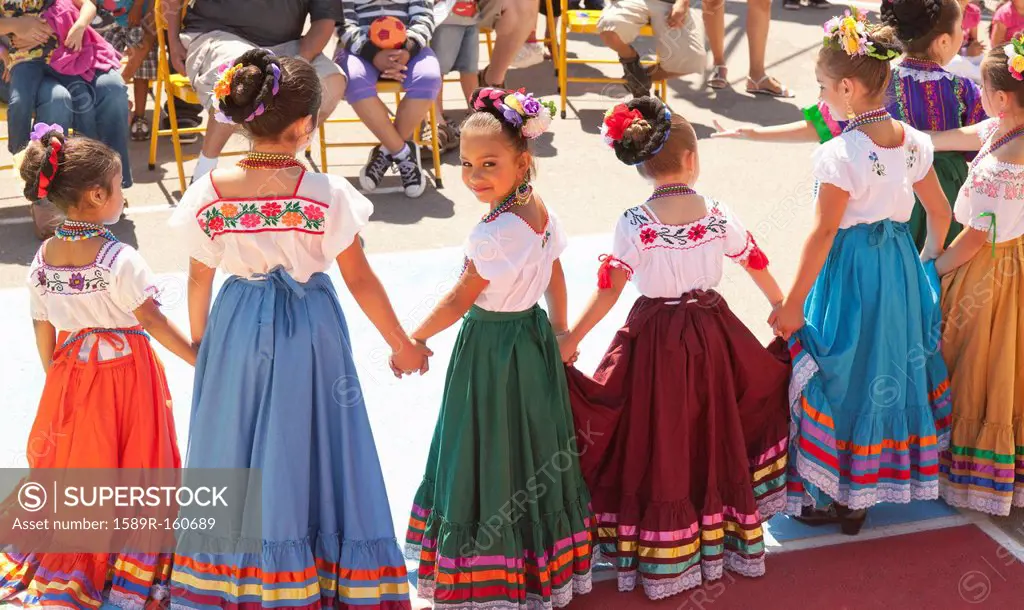 Hispanic girls dancing in costumes