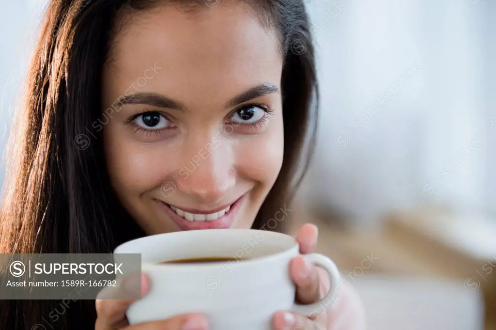 Hispanic teenager drinking coffee