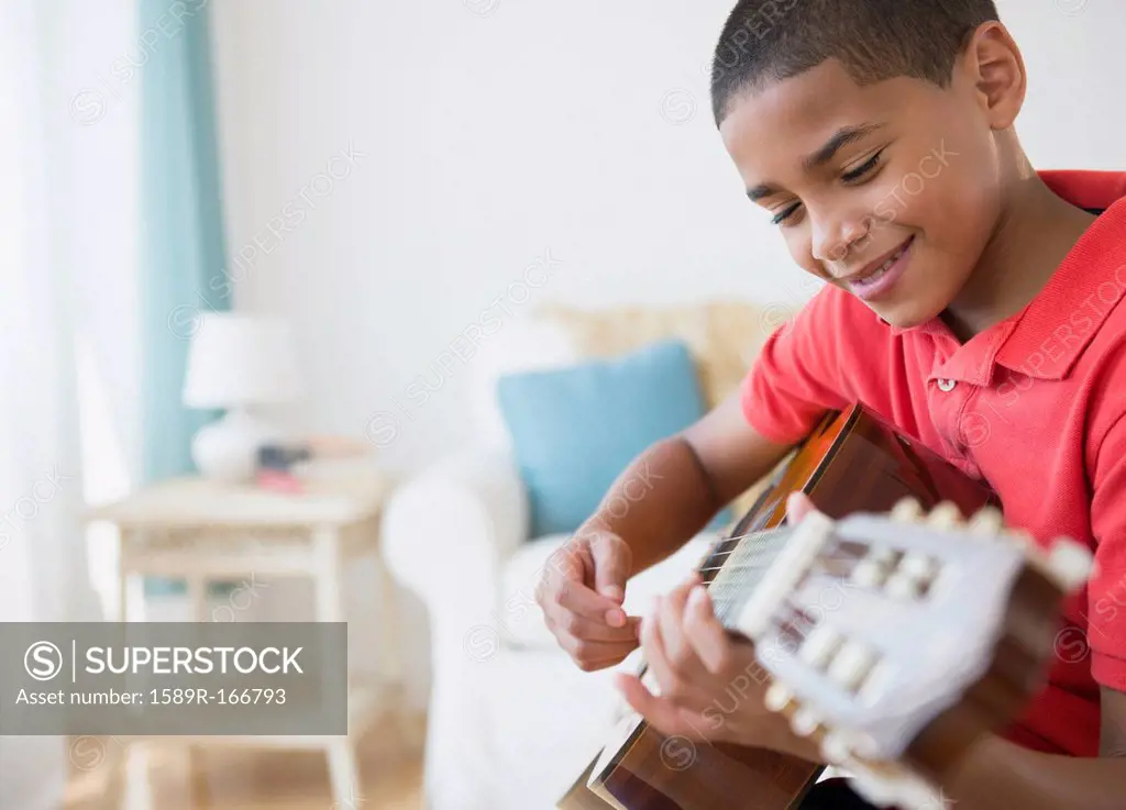 Hispanic boy playing guitar