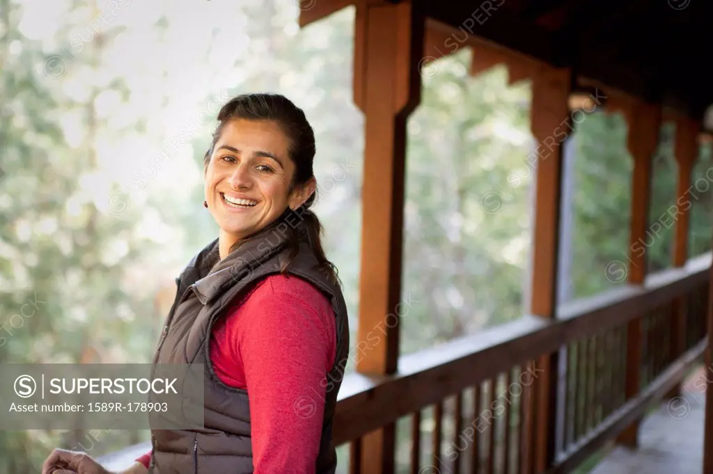 Hispanic woman smiling on porch