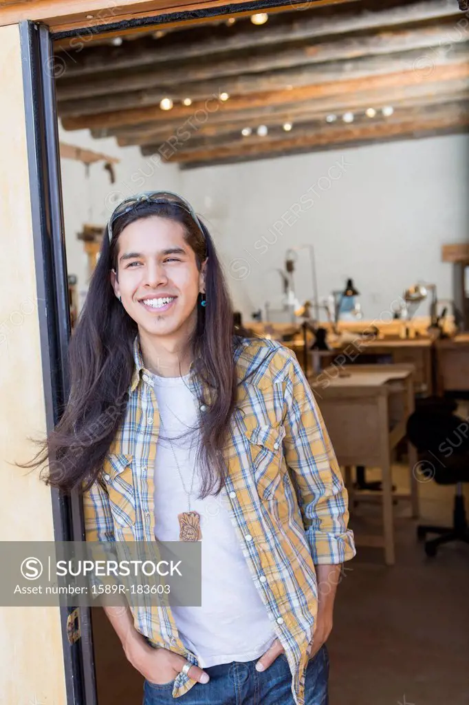 Mixed race man standing in doorway of art studio