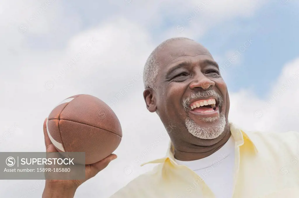 Black man throwing football outdoors