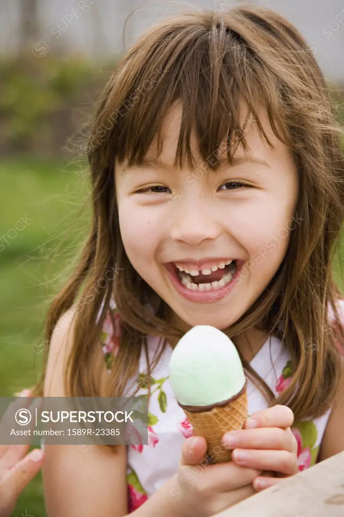 Young Asian girl eating ice cream cone