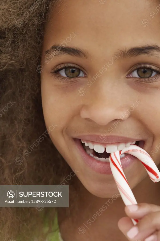 Close up of African American girl eating candy cane