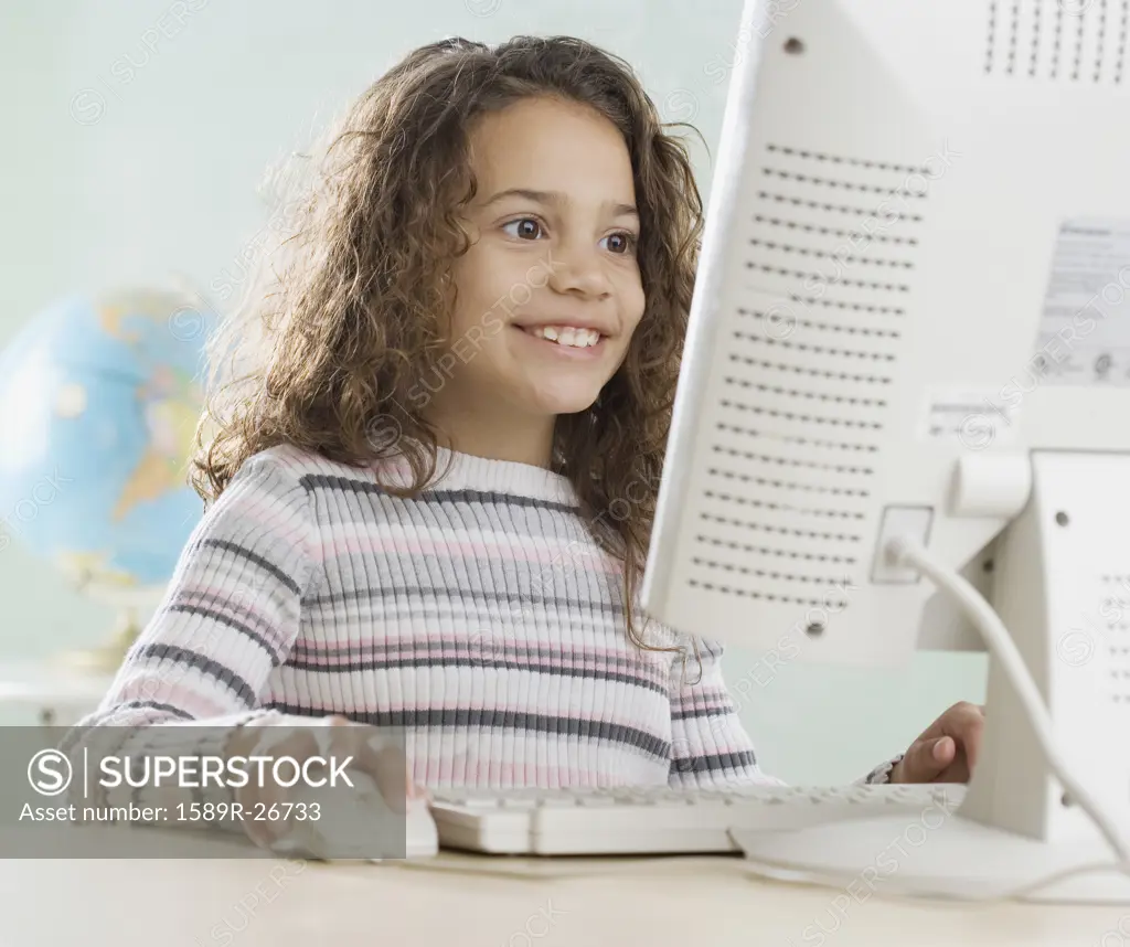 Young girl using computer in classroom