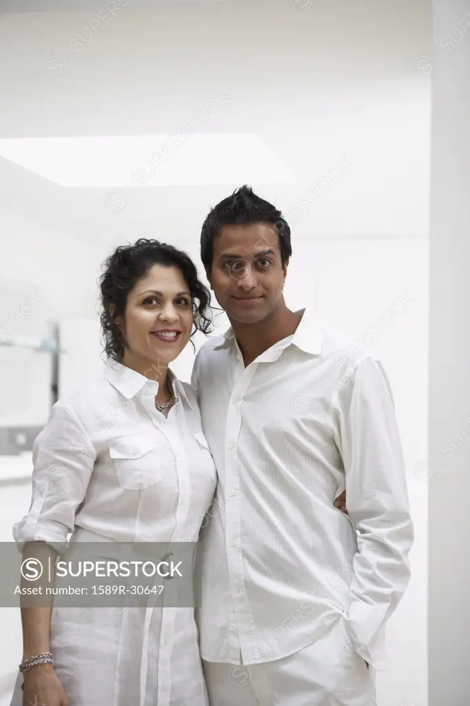 Middle Eastern couple hugging and smiling indoors