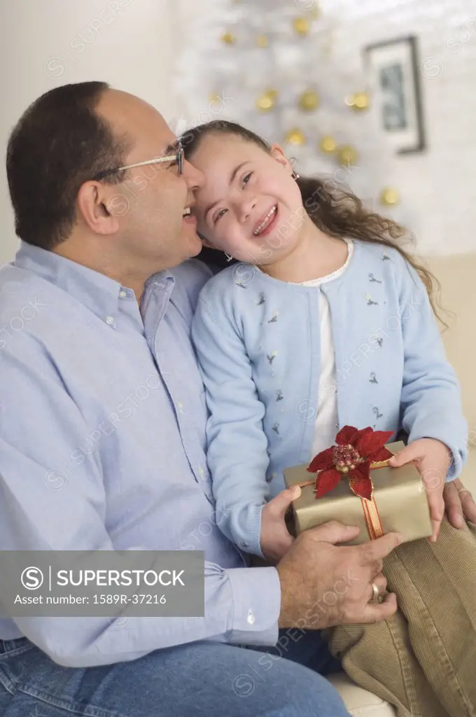 Hispanic grandfather giving gift to granddaughter