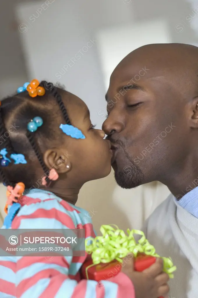 African girl giving gift to father