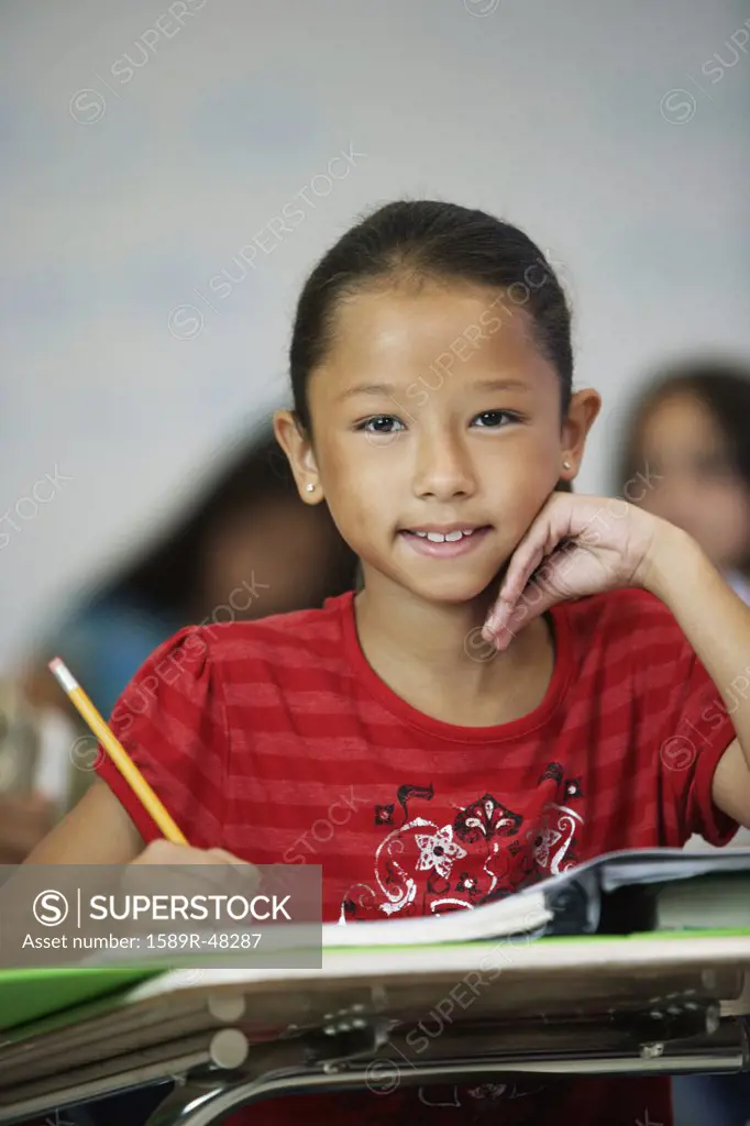 Asian girl at desk in classroom