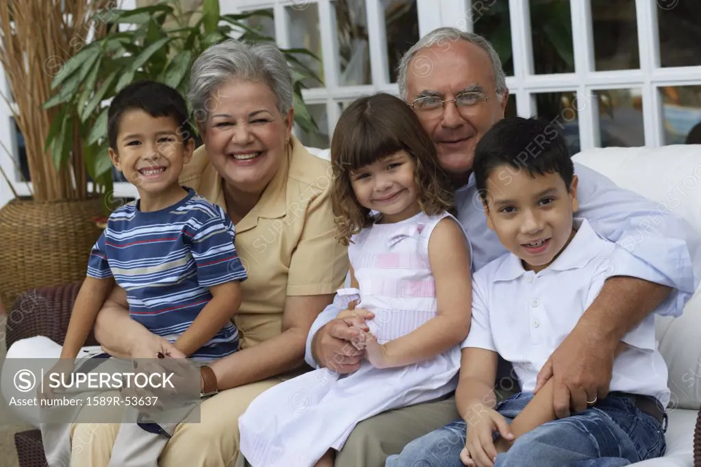 Hispanic grandparents hugging grandchildren