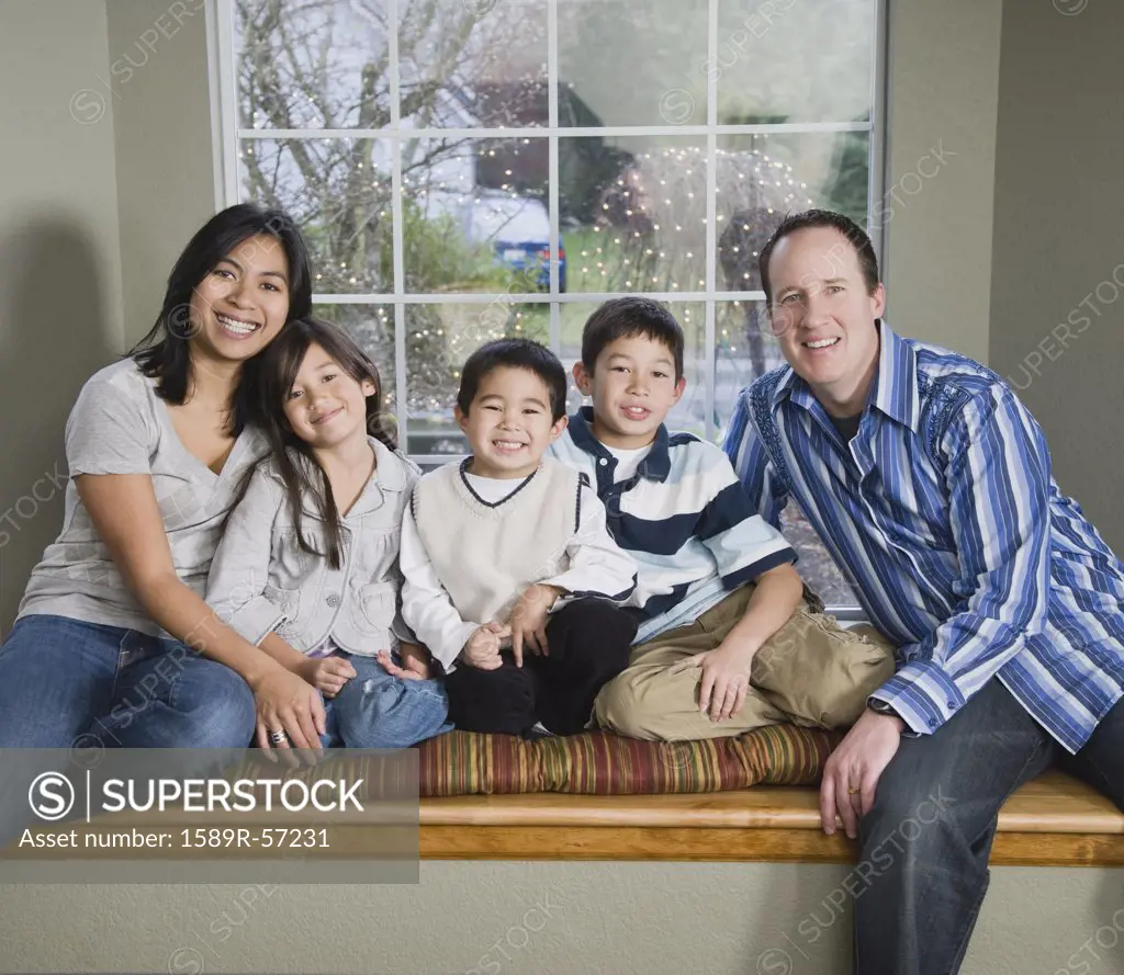 Mixed Race family in front of window