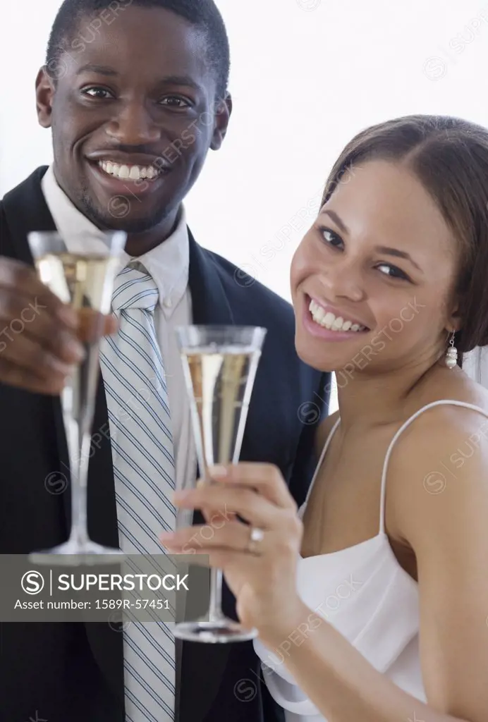 African newlyweds toasting with champagne