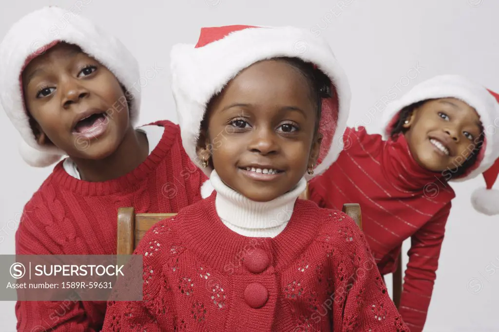 African siblings wearing Santa Claus hats