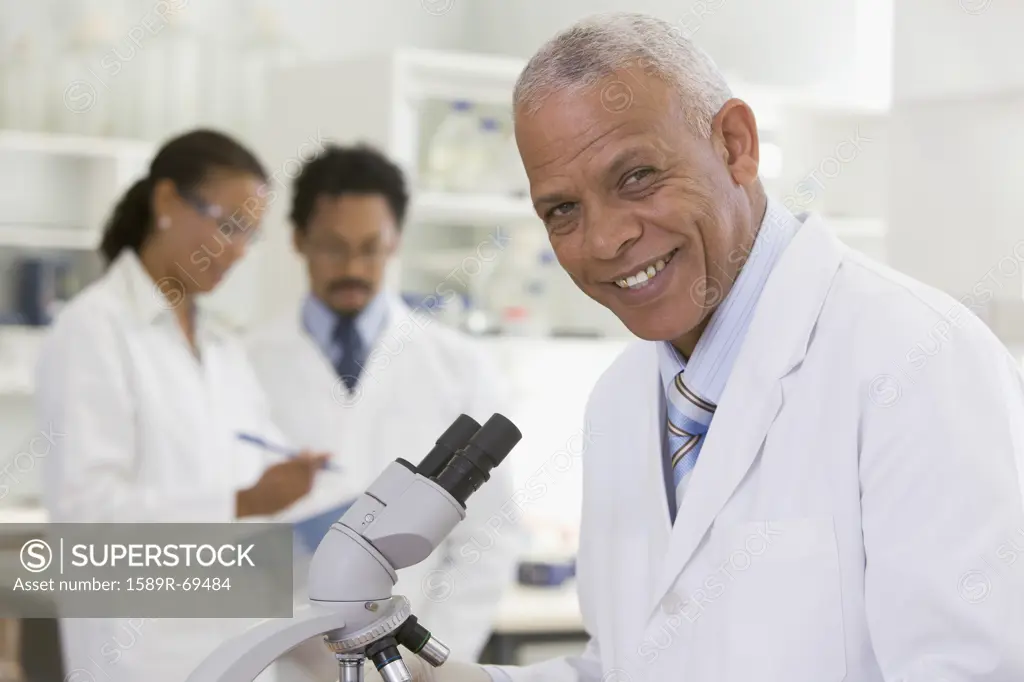 African scientist performing analysis in laboratory with microscope