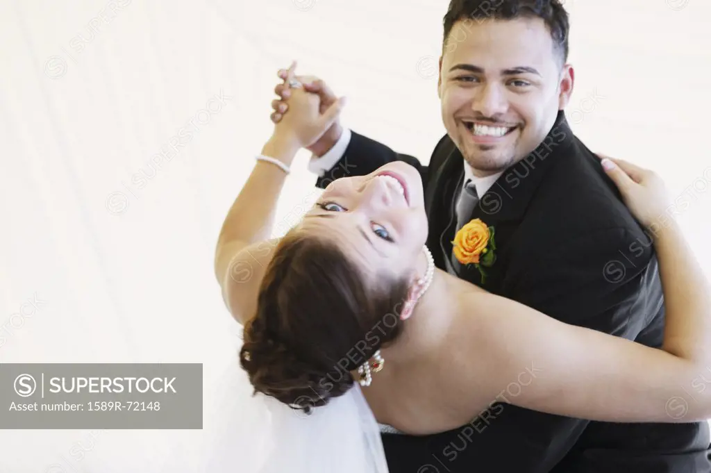 Multi-ethnic bride and groom dancing