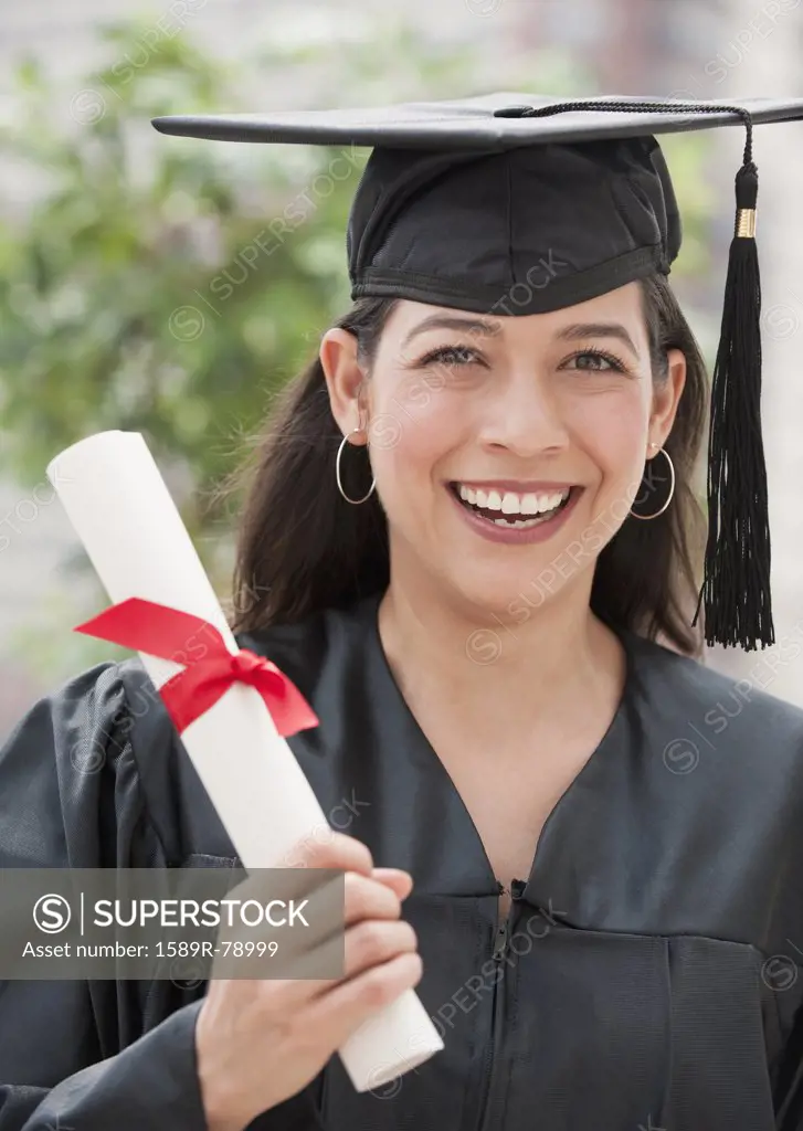 Hispanic graduate holding diploma