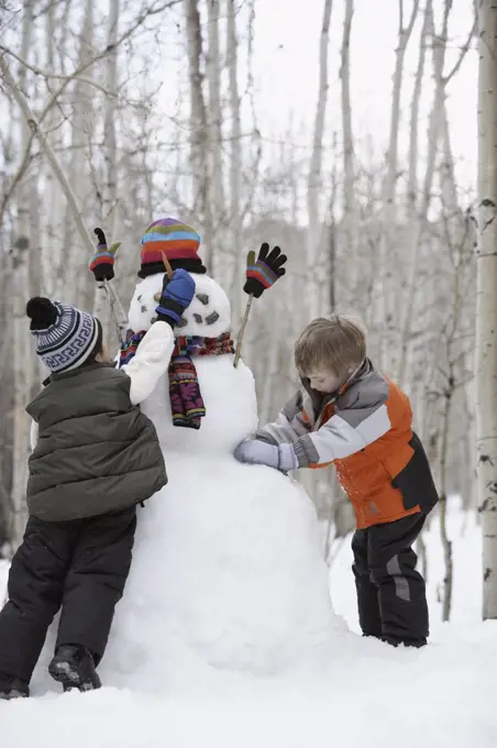 Two boys making a snowman