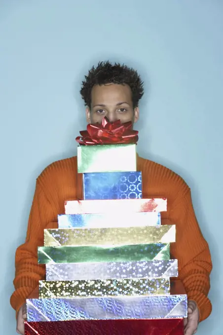 Young man behind stack of gifts