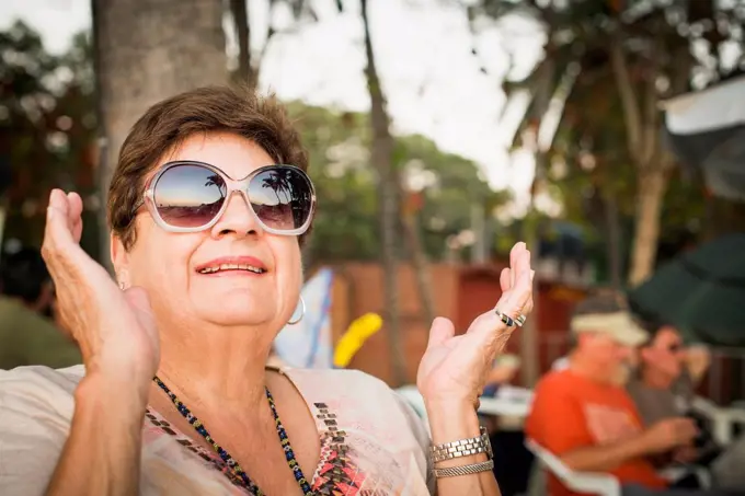 Older woman clapping outdoors