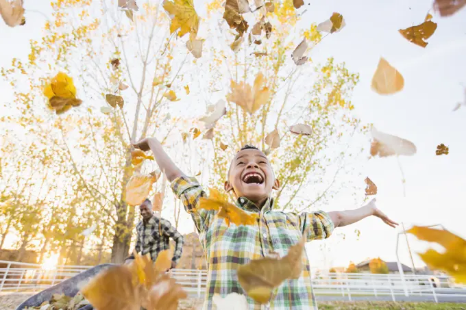 Boy playing in autumn leaves