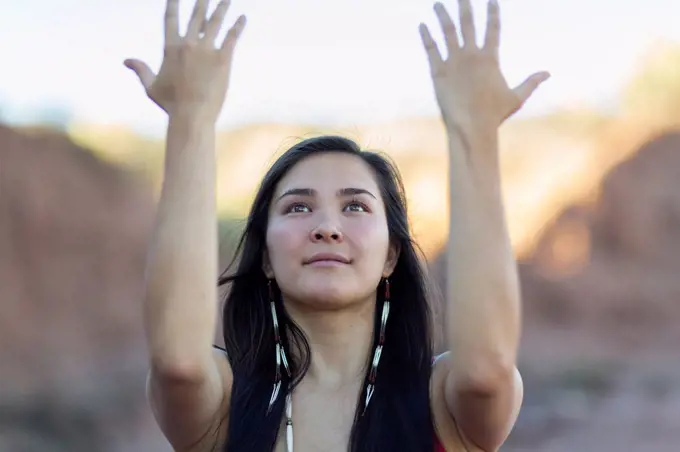 Mixed race woman meditating in desert