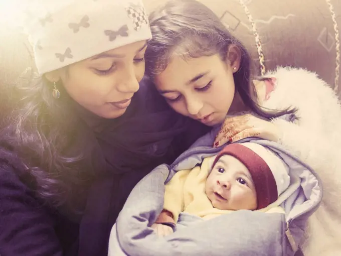 Girl admiring baby nephew with aunt