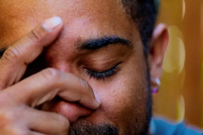 Close up of mixed race man holding head in hands