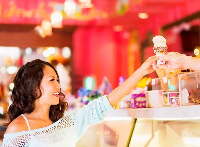 Chinese woman buying ice cream cone in shop