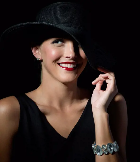 Stylish Caucasian woman wearing black hat and dress