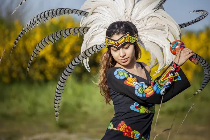 Native American woman in traditional headdress performing ceremony