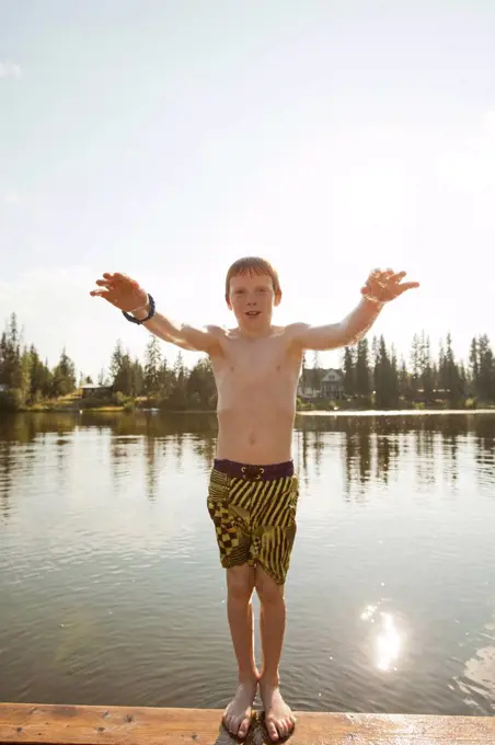 Caucasian boy falling backwards into lake