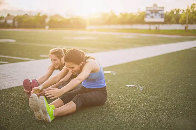 Athletes stretching on sports field