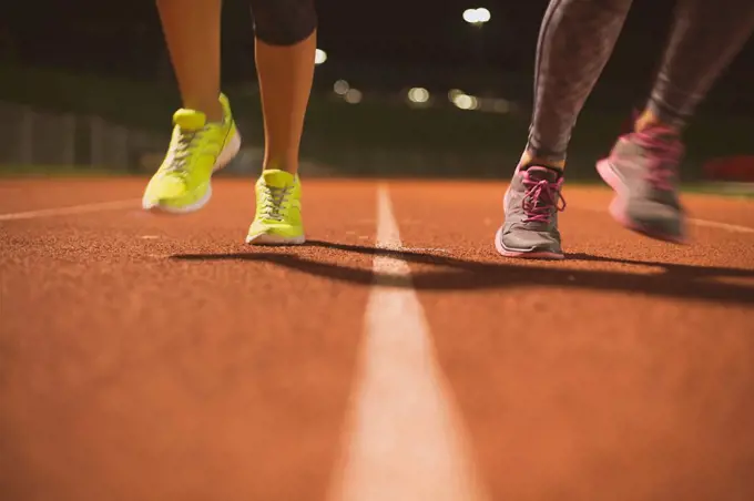 Athletes running on track on sports field