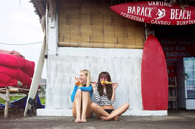 Caucasian women eating at surf hut on beach