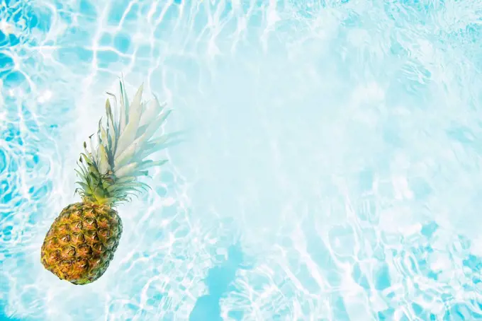 Pineapple floating in swimming pool