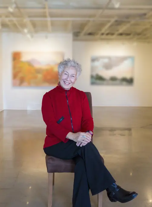 Older mixed race woman smiling in art gallery