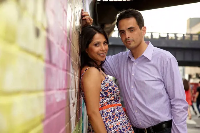 Couple leaning on urban wall