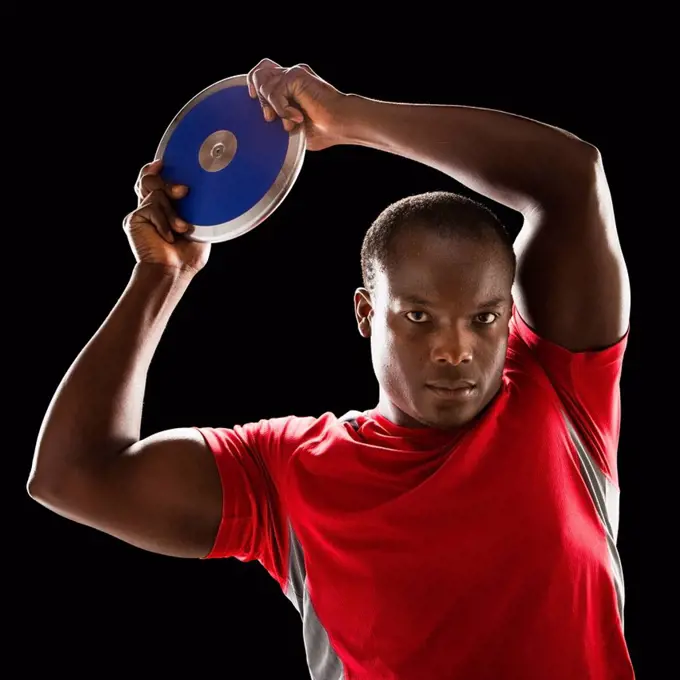 African American man holding track and field discus