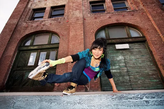 Chinese woman breakdancing in urban area