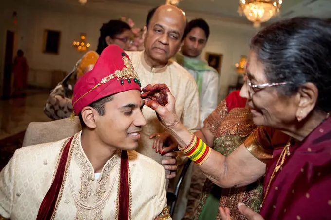 Indian woman marking groom's face