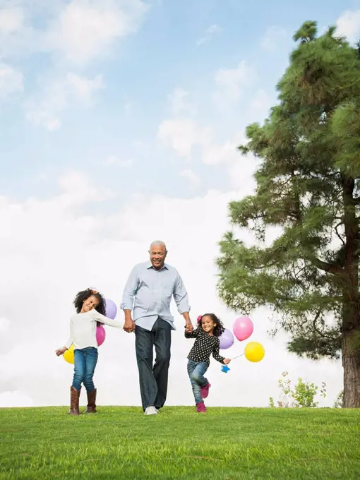 Man walking with granddaughters in park