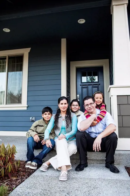 Family smiling on front stoop