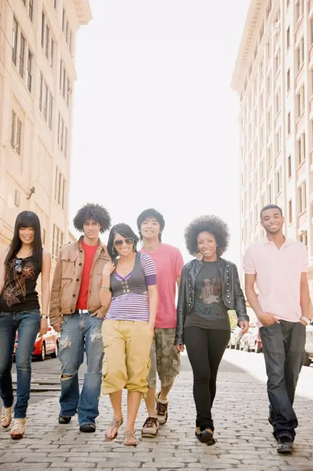 Multi-ethnic friends walking down urban sidewalk