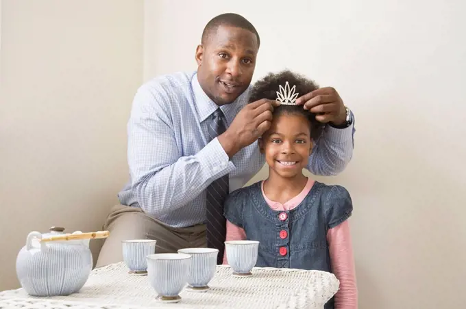 African father and daughter posing with tiara