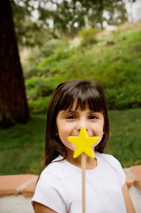 Mixed race girl holding star wand