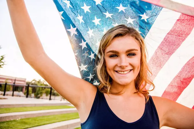 Caucasian teenage girl holding American flag